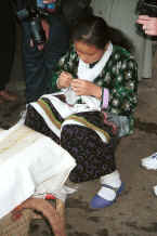 Jpeg 29K Young Side comb Miao woman working on embroidery for one of the strips to be inserted in a skirt - Long Dong village, De Wo township, Longlin country, Guangxi province 0010e22.jpg