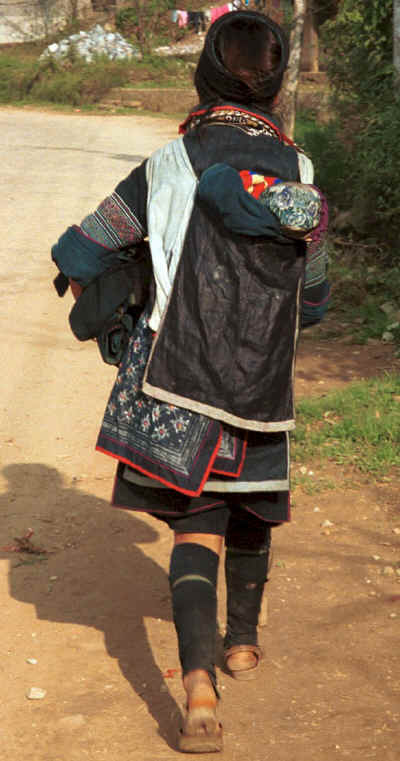 Black Hmong mother carrying her baby in a carrier walking out of Sa pa, Northern Vietnam, to her home village 9510i23.jpg
