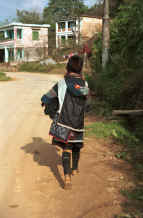 to Jpeg 35K Black Hmong mother carrying her baby in a carrier walking out of Sa pa, Northern Vietnam, to her home village 9510I23