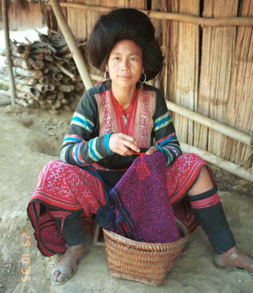 Green Hmong woman working (from the back) on the cross-stitch border of the bottom band of a new skirt similar to the one which she is wearing. 9510f31.jpg